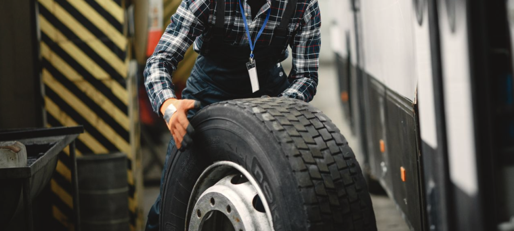 Technician rolling a tire and wheel to provide truck and trailer tire repair services